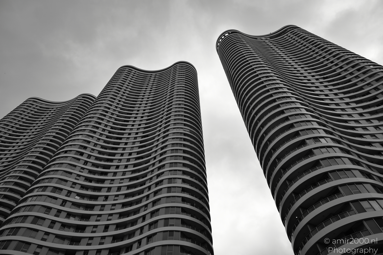 Gindi Towers balconies curving into a cloudy Tel Aviv sky