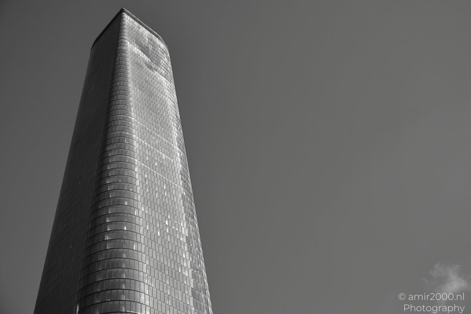 Beyond Tower glass facade narrowing toward roofline in Givatayim Israel