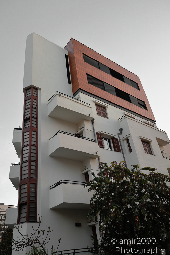 Modern rooftop addition extending above a white Bauhaus facade in Tel Aviv-Jaffa, Israel