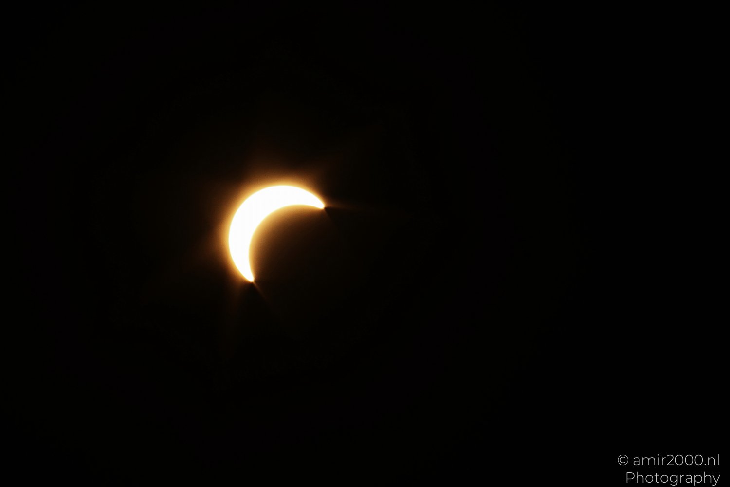 Solar crescent emerging during a partial solar eclipse in Amsterdam