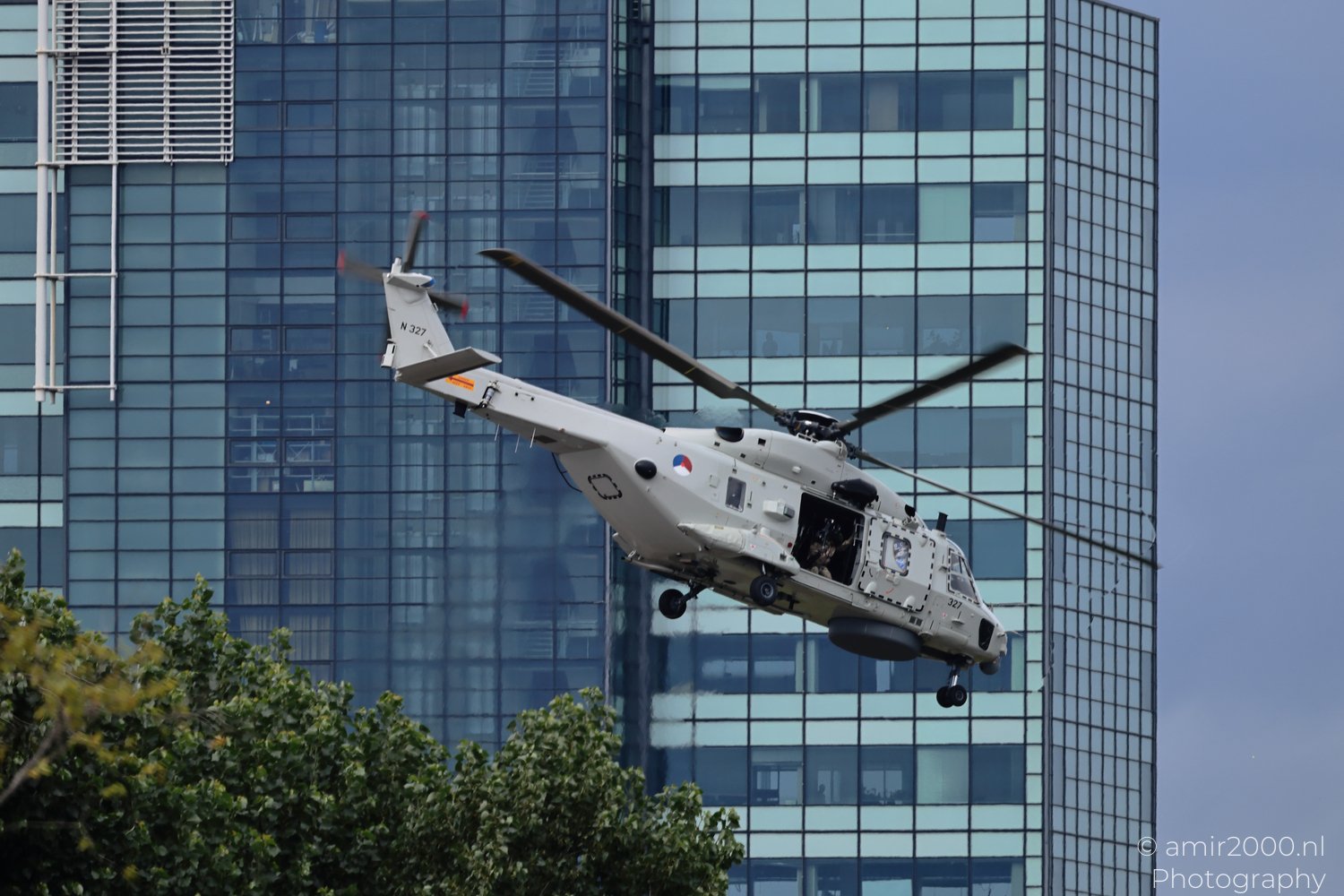 Royal Netherlands Navy NH90 NFH maneuvering near high-rise buildings in Amsterdam