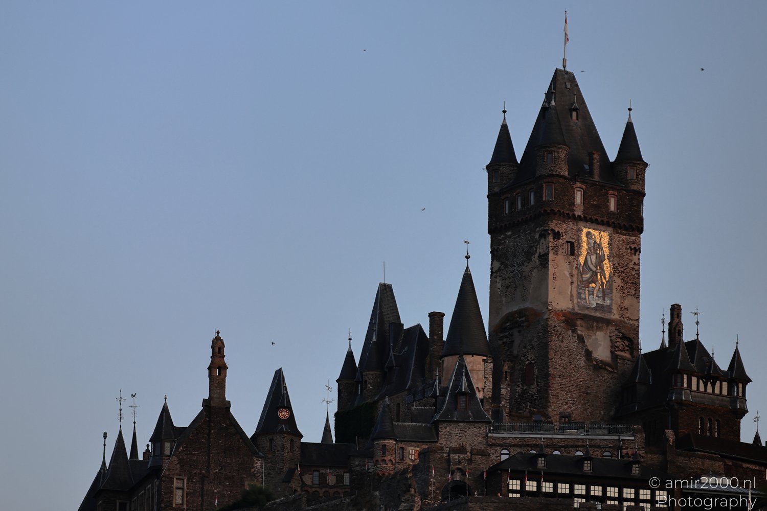 Reichsburg Cochem tower above darkening rooftops