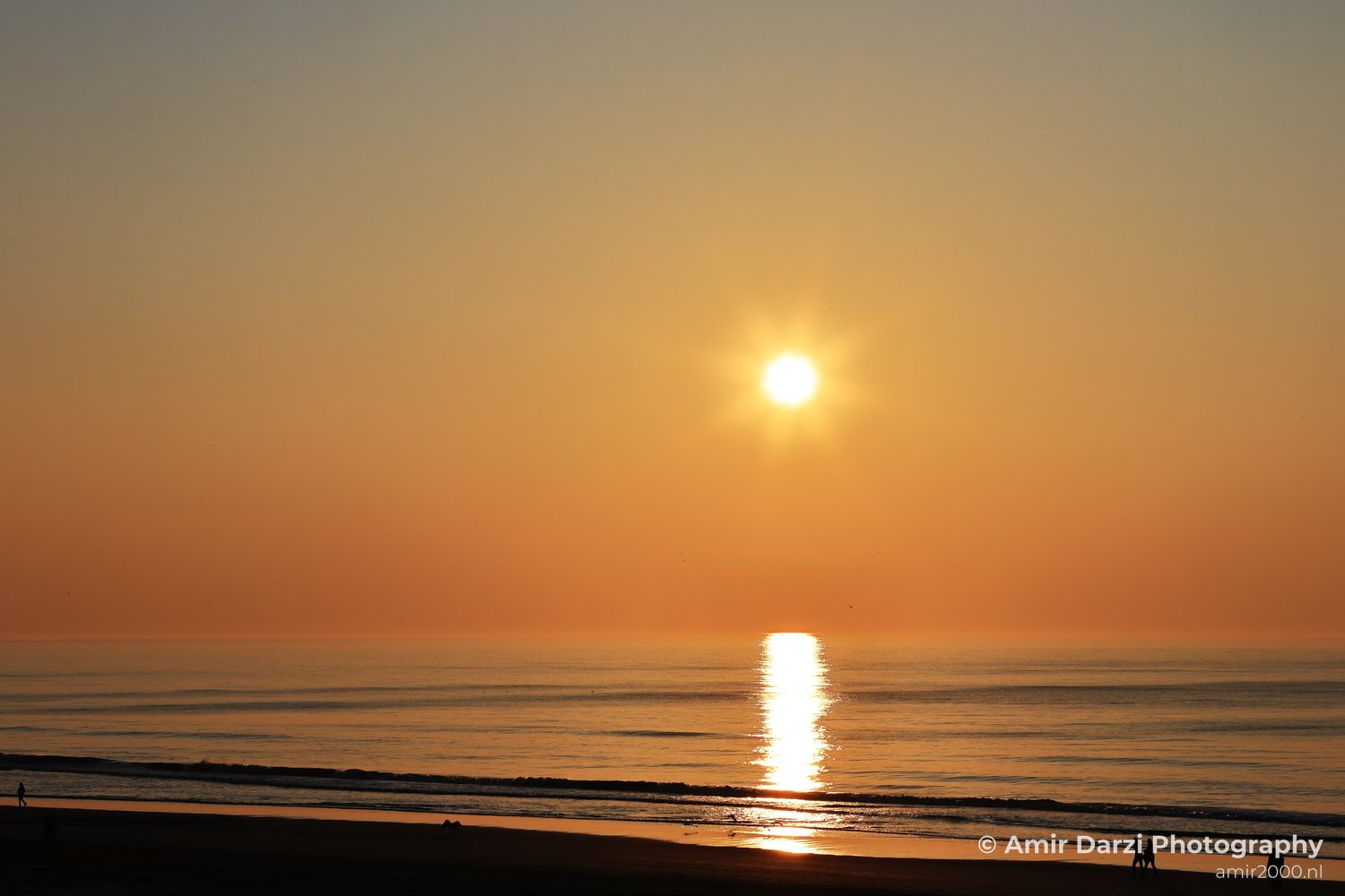 A sunset over the North Sea, with the sun setting and the water shimmering in the golden light.