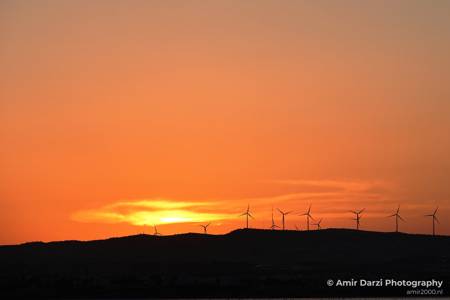 Sunset scene with an orange and yellow gradient sky transitioning to darker hues at the horizon in Larnaca, Cyprus.