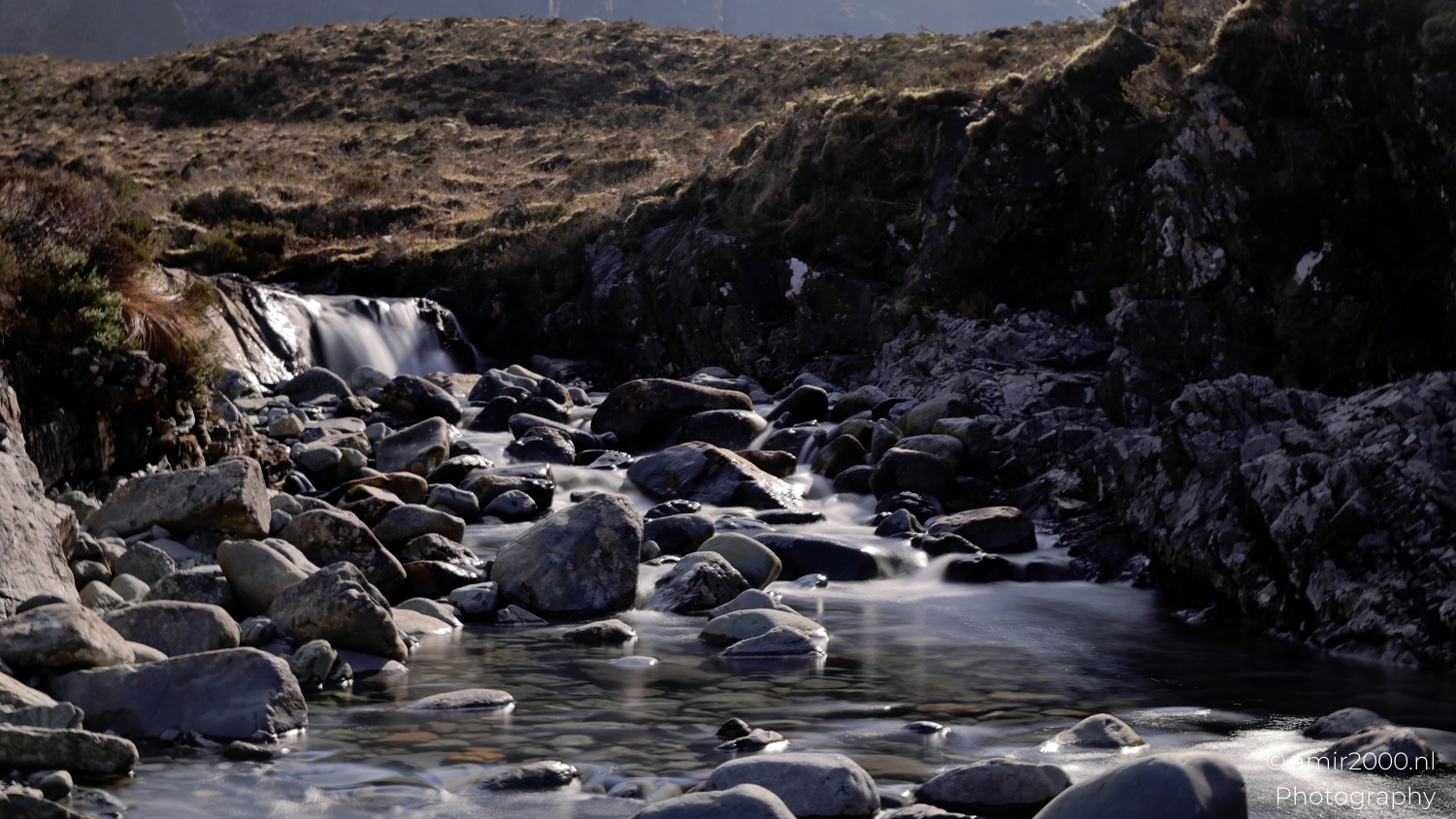 Rocky stream flowing over small waterfall at Fairy Pools in Glen Brittle