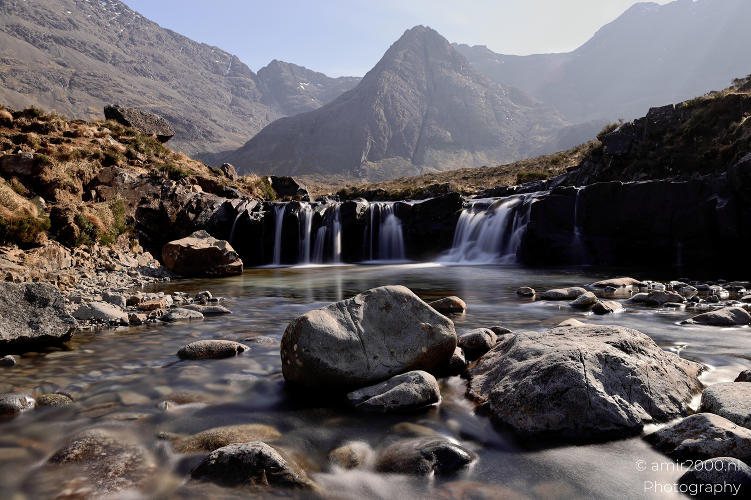 Fairy Pools waterfall dropping into rocky pool below Cuillin mountains