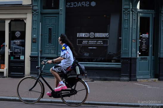 Bicyclist_Riding_Past_Store_Amsterdam_Netherlands_People_Creative_Collection_Photography_Canon_EOS_R5_Mark_II_2026_001.JPG