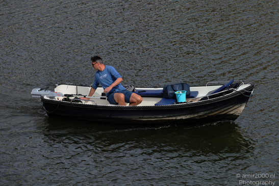 A man rows a small boat on calm water. - image from year 2026 #001