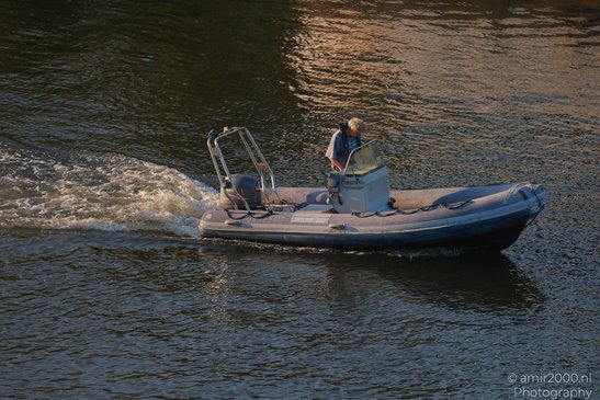 A person is steering a motorized inflatable boat on water it in Amsterdam, Netherlands. - image from year 2026 #006