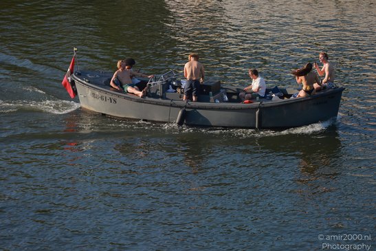 A group of people enjoying a boat ride on calm water in Amsterdam, Netherlands. - image from year 2026 #009