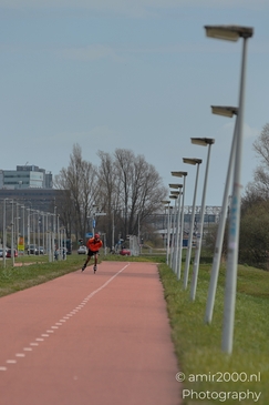 A rollerblader glides along a bike path lined with streetlights and trees in the distance. - image from year 2026 #001