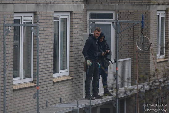 Two individuals standing on a platform, wearing work attire and gloves in Amsterdam, Netherlands. - image from year 2026 #003