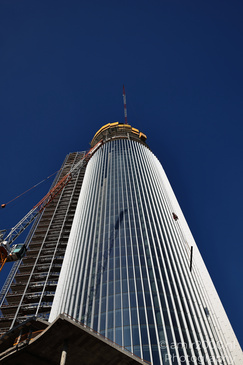 Azrieli Spiral Tower construction with scaffolding on the left side against a clear blue sky in - image from year 2026 #007