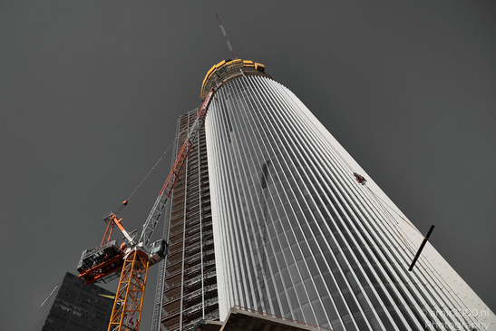 A tall building under construction is shown from below with scaffolding around it, a crane to - image from year 2026 #009
