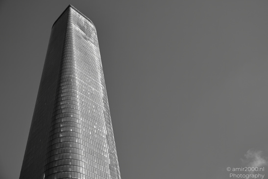 A tall, slender structure with a textured surface against a dark sky, partially illuminated by - image from year 2026 #008