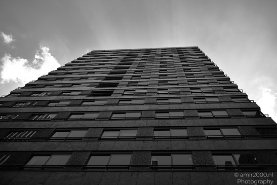 A towering high rise building viewed from below against a cloudy sky. - image from year 2026 #001