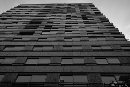 A tall, dark building with numerous windows and balconies. - image from year 2026 #002