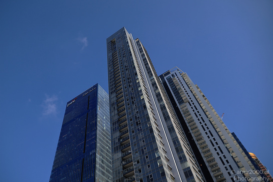 Three modern high rise buildings under a clear blue sky, with the tallest structure prominently - image from year 2026 #002