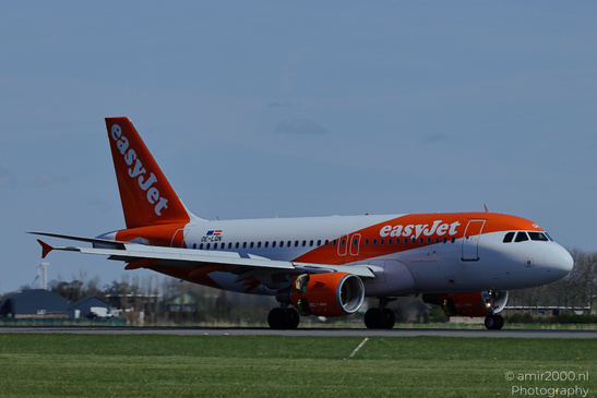 An easyJet aircraft on a runway with its landing gear deployed and grassy fields surrounding it - image from year 2026 #001
