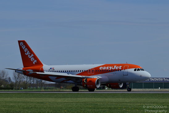 An easyJet aircraft on a runway with its landing gear deployed and grassy areas surrounding it - image from year 2026 #002