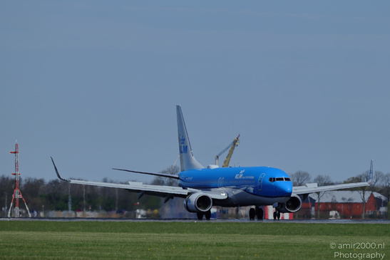 A KLM Royal Dutch Airlines aircraft is taxiing on a runway with grass and structures in the - image from year 2026 #001