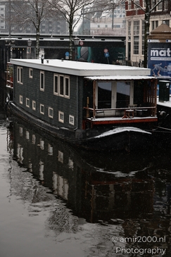 Boat_With_Snow_On_Deck_In_Canal_Amsterdam_Netherlands_Cityscape_Photography_Canon_EOS_R5_Mark_II_2026_001.JPG