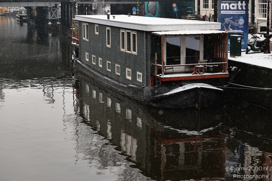 Boat_With_Snow_On_Deck_In_Canal_Amsterdam_Netherlands_Cityscape_Photography_Canon_EOS_R5_Mark_II_2026_002.JPG