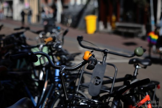 A close up of a bicycle handlebar with a yellow bell, surrounded by other bicycles, and a - image from year 2026 #005