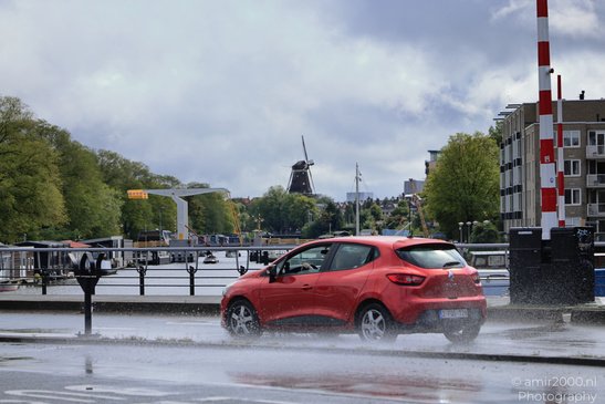 Red_Car_Driving_Through_Rain_Amsterdam_Netherlands_Cityscape_Photography_Canon_EOS_R5_Mark_II_2026_001.JPG