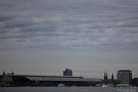 Centraal Station harbor with a mix of modern and historical buildings under an overcast sky. - image from year 2026 #001