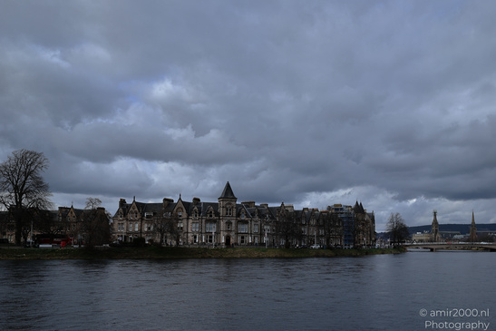 A Scottish cityscape with a river and historic buildings under an overcast sky. - image from year 2026 #005