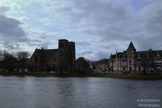 A Scottish cityscape with historic buildings by the river under a cloudy sky. - image from year 2026 #007