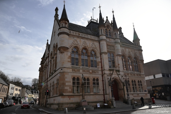 A historic building with ornate architecture and a clock tower in the Scottish Highlands. - image from year 2026 #013