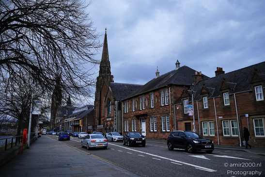 A quaint Scottish town street with a church spire and historic buildings. - image from year 2026 #014