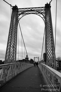 Scottish City Inverness a black and white photograph of a suspension bridge with intricate - image from year 2026 #024