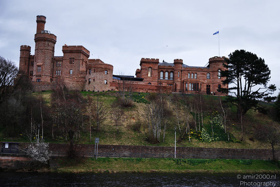 Scottish City Inverness a historic castle with red brick walls and a flagpole stands on a hill - image from year 2026 #039