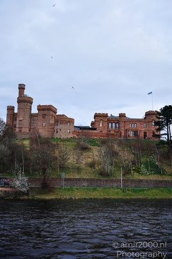 Scottish City Inverness a historic castle with red brick walls and a flag on top overlooks a - image from year 2026 #040