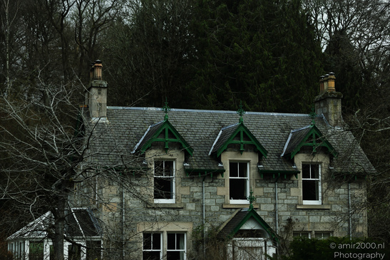 Town Pitlochry a quaint stone house with a steeply pitched roof and ornate dormer windows - image from year 2026 #001