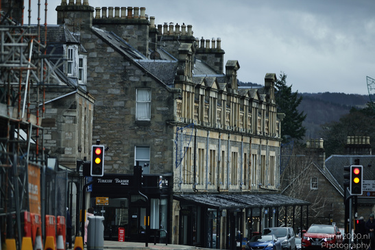 A quaint town street with historic buildings and a cloudy sky. - image from year 2026 #002