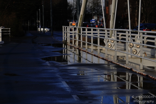 White_Bridge_Railings_Reflecting_On_Wet_Pavement_After_Snow_Amsterdam_Netherlands_Cityscape_Photography_Canon_EOS_R5_Mark_II_2026_001.JPG