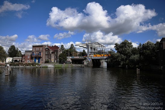Willemsbrug Haarlemmerplein: A canal with a reflection of the surrounding buildings and - image from year 2026 #002