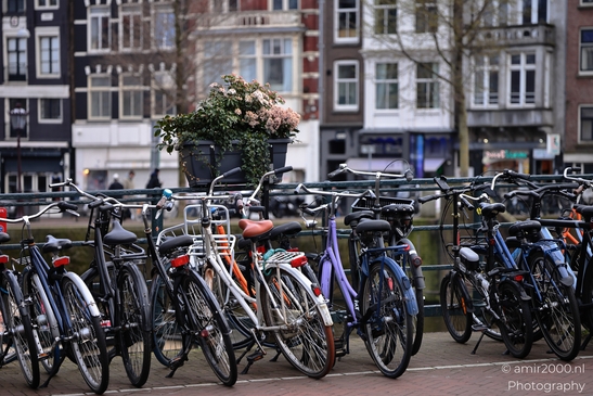Numerous bicycles lined up along a railing, typical of urban settings in Amsterdam, Netherlands. - image from year 2026 #002