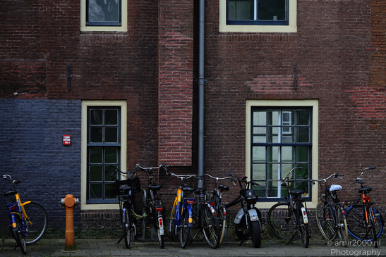 Bicycles appear and parked against a brick building in Amsterdam, Netherlands. - image from year 2026 #001