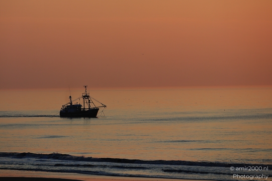 Sunset with fishing boats and a lone figure on the beach. - image from year 2026 #002
