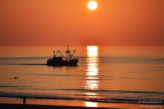 A sunset over the North Sea with a fishing boat and a lone figure on the beach. - image from year 2026 #004