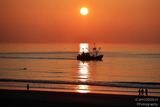 A sunset over the North Sea, with a fishing boat and a lone figure on the beach. - image from year 2026 #009