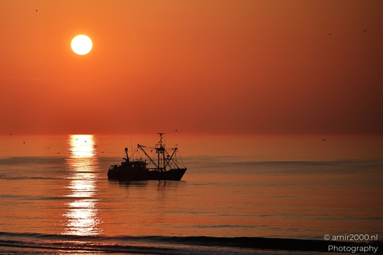 A fishing boat at sunset on the North Sea, with the sun setting. - image from year 2026 #010