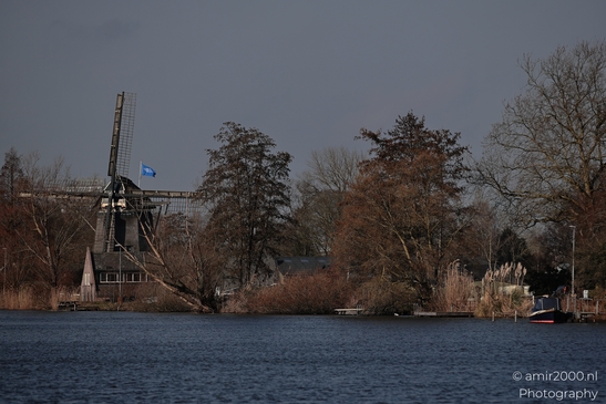 A traditional windmill stands beside a body of water in Driemond, Netherlands. - image from year 2026 #002