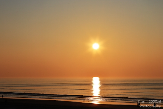 A sunset over the North Sea, with the sun casting a warm glow on the horizon and the calm sea - image from year 2026 #001