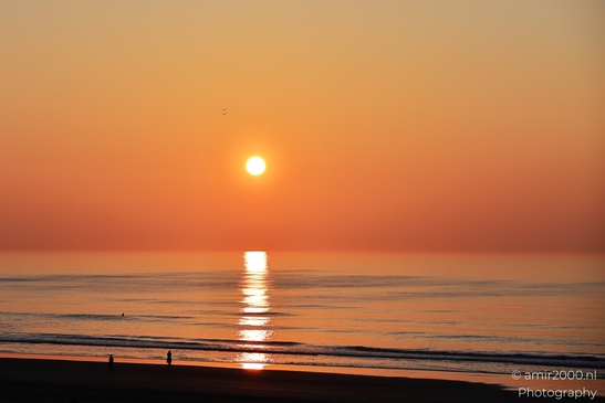 A sunset over the North Sea, with the sun setting low on the horizon, casting a warm orange glow - image from year 2026 #002